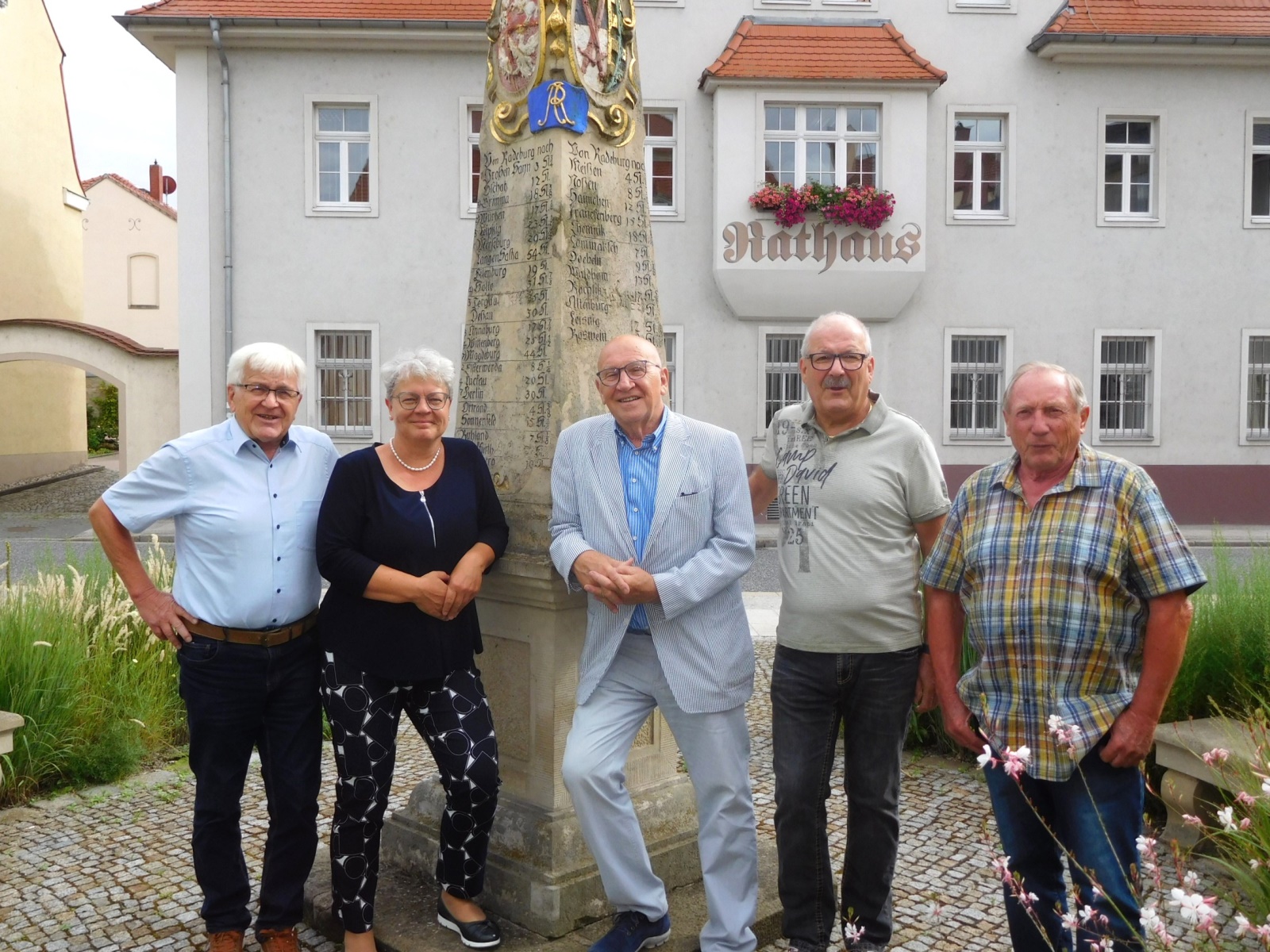 Vorstand des Partnerschaftsvereins Radeburg e.V. - Mitglieder stehen an der Postmeilensäule vor dem Rathaus in Radeburg